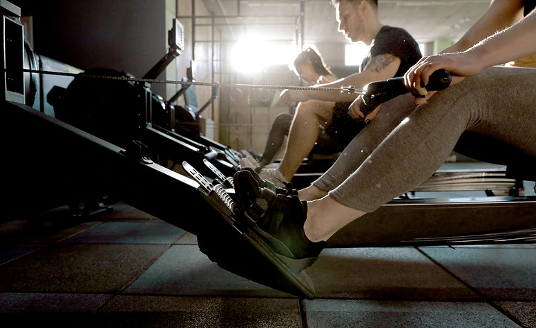 Group of athletes performing CrossFit row workouts to show how sports massage and assisted stretching can optimize workouts